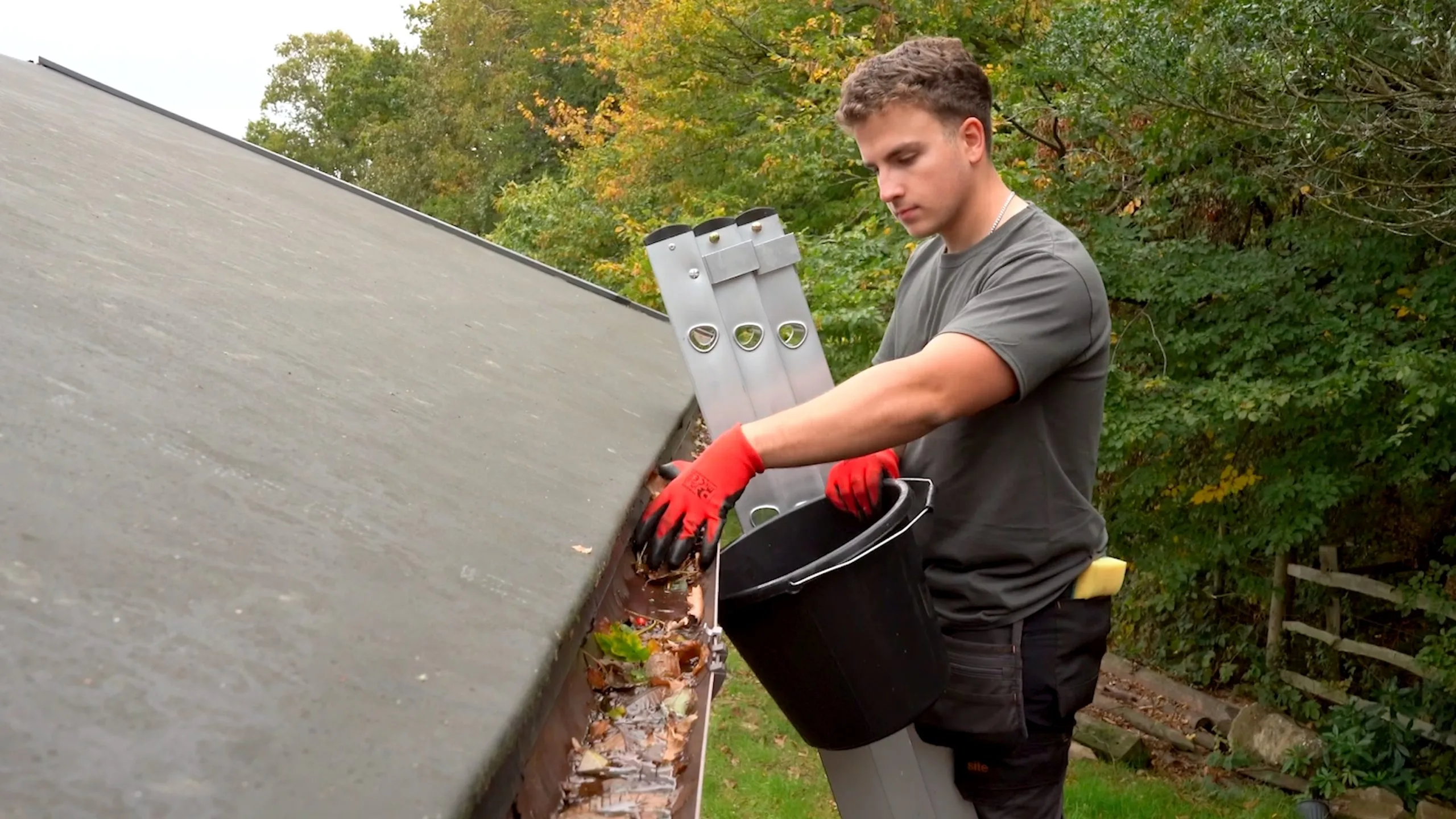 London gutter cleaning technician removing debris from a blocked gutter